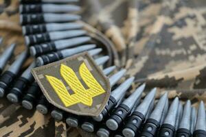 ucranio Ejército símbolo en máquina pistola cinturón mentiras en ucranio pixelado militar camuflaje foto