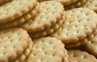 Detailed picture of round sandwich cookies with coconut filling. Background image of a close-up of several treats for tea photo