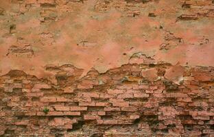 Very old damaged red brick wall with boneless bricks and cement mortar photo