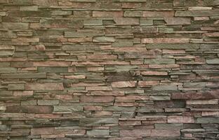 Texture of a stone wall from long and rough stones of different sizes and tones photo