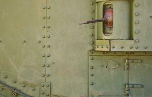 The texture of the wall of the tank, made of metal and reinforced with a multitude of bolts and rivets. Images of the covering of a combat vehicle from the Second World War with a guided machine gun photo