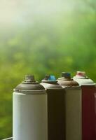 A few used aerosol paint sprayers lie on the windowsill in the workshop of a graffiti artist. The concept of street art and illegal drawing on the walls. Youth hobby photo