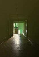 The gloomy corridor of a neglected public building. Public space in a poor residential high-rise building photo