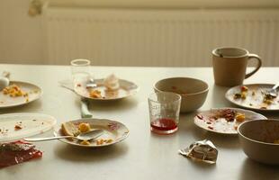 Empty dirty plates with spoons and forks on the table after meal. Banquet ending concept. Unwashed dishes photo