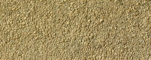 Texture of a stone wall with small round pebble stones. Part of a stone wall as a background or texture photo