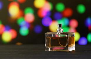 Women fragrance perfume bottle on dark festive background close up. Unnamed blank sprayer bottle of perfume photo