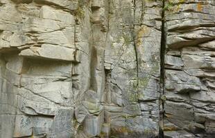 Light coarse natural rock stone background. Mining cliff rough front surface. Big limestone stack backdrop. Heavy grunge damaged granite block texture photo