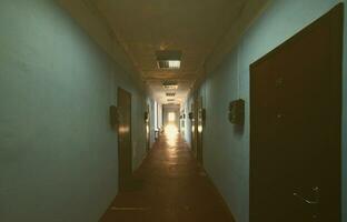 The gloomy corridor of a neglected public building. Public space in a poor residential high-rise building photo