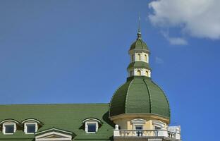 Completed perfect high-quality roofing work from metal roofing. The dome of a polyhedral shape with a spire is covered with green metal tiles photo