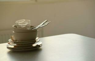 Stack of dirty dishes with food leftovers on the table after meal. Banquet ending concept. Unwashed dishes photo