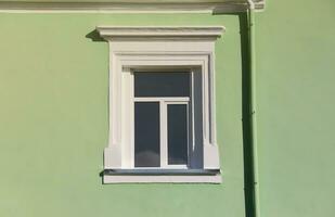 Vintage white window on mint green wall in sunlight photo