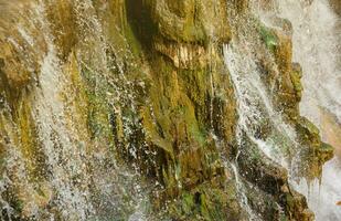 Beautiful waterfall between large rocks in autumn forest. Sofievskiy park in Uman, Ukraine photo