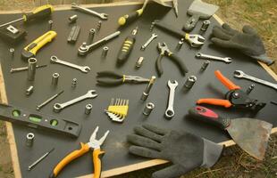 Handyman tool kit on black wooden table. Many wrenches and screwdrivers, pilers and other tools for any types of repair or construction works. Repairman tools photo