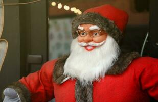 Santa claus big plastic figure with classic santa clothes close to wooden house photo