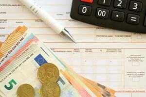 Filling italian tax form process with pen, calculator and euro money bills close up. Tax paying period photo