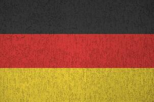 Germany flag depicted in bright paint colors on old relief plastering wall. Textured banner on rough background photo