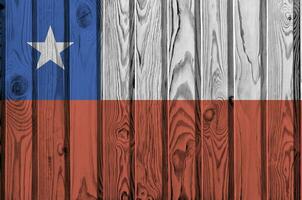 Chile flag depicted in bright paint colors on old wooden wall. Textured banner on rough background photo