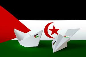 Western Sahara flag depicted on paper origami airplane and boat. Handmade arts concept photo