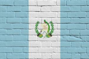 Guatemala flag depicted in paint colors on old brick wall. Textured banner on big brick wall masonry background photo