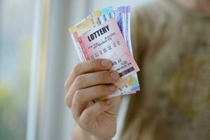 Man hands with indian rupees bills and lottery ticket. Concept of gambling and winning money in indian lottery photo