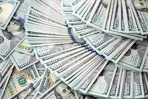 Very big amount of US hundred dollar bills. Huge quantity of united states currency notes on flat table photo
