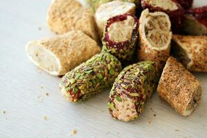 Rolls of turkish delight with different flavors and fillings close up on table photo