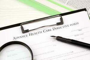 Advance health care directive blank form on A4 tablet lies on office table with pen and magnifying glass photo