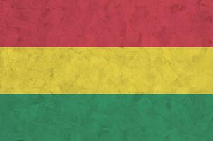 Bolivia flag depicted in bright paint colors on old relief plastering wall. Textured banner on rough background photo