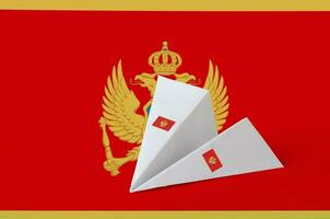 Montenegro flag depicted on paper origami airplane. Handmade arts concept photo