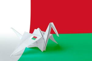Madagascar flag depicted on paper origami crane wing. Handmade arts concept photo