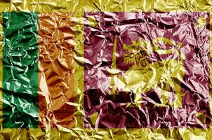 Sri Lanka flag depicted in paint colors on shiny crumpled aluminium foil closeup. Textured banner on rough background photo