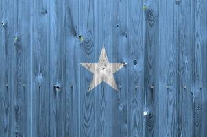 Somalia flag depicted in bright paint colors on old wooden wall. Textured banner on rough background photo