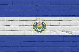 el el Salvador bandera representado en pintar colores en antiguo ladrillo pared. texturizado bandera en grande ladrillo pared albañilería antecedentes foto