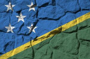 Solomon Islands flag depicted in paint colors on old stone wall closeup. Textured banner on rock wall background photo