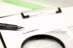 Model Release on A4 tablet lies on office table with pen and magnifying glass photo