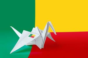 Benin flag depicted on paper origami crane wing. Handmade arts concept photo