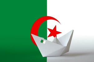 Algeria flag depicted on paper origami ship closeup. Handmade arts concept photo