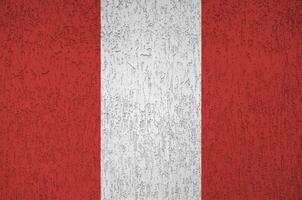 Peru flag depicted in bright paint colors on old relief plastering wall. Textured banner on rough background photo