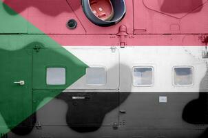 Sudan flag depicted on side part of military armored helicopter closeup. Army forces aircraft conceptual background photo