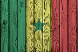 Senegal bandera representado en brillante pintar colores en antiguo de madera pared. texturizado bandera en áspero antecedentes foto