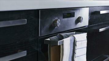 Close-up of white smoke coming out of a stainless steel electric oven. Stock footage. Modern kitchen appliances photo