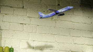 Homemade airplane in the room. On the background of stone wall hanging toy airplane on a rope, the concept of hand made photo