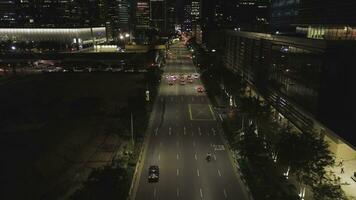 Top view of street with cars and modern buildings in big Chinese city at night. Shot. Night aerial view of city center with its road, moving cars, lights of skyscrapers, night life concept. photo