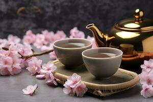 AI generated Traditional ceremony. Cups of brewed tea, teapot and sakura flowers on grey table. Generative AI photo