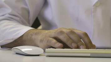 Closeup of a man using computer. His shirt and tie in background photo