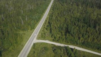 Top view scenic winding country road through green farmland. Clip. Aerial rural road countryside photo