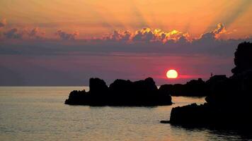 le coucher du soleil plus de le mer avec rochers et des nuages video