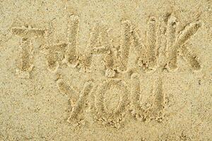Thank you text on sand photo