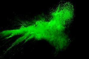 Green color powder explosion cloud on black background.Green dust splash. photo