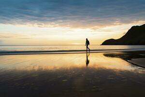 AI generated A person walking on the beach at sunset. AI Generated. photo